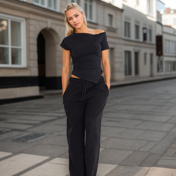 Kvindernes asymmetriske top med moderigtig halterneck design og dekorativt udsnit Stilla