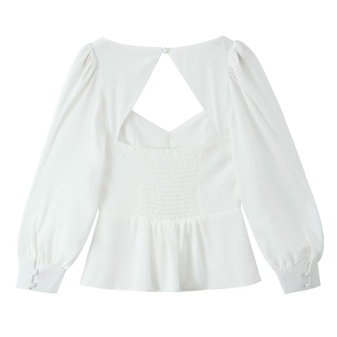 Damebluse med raffinerede puffærmer og elegant rygudskæring Stilla