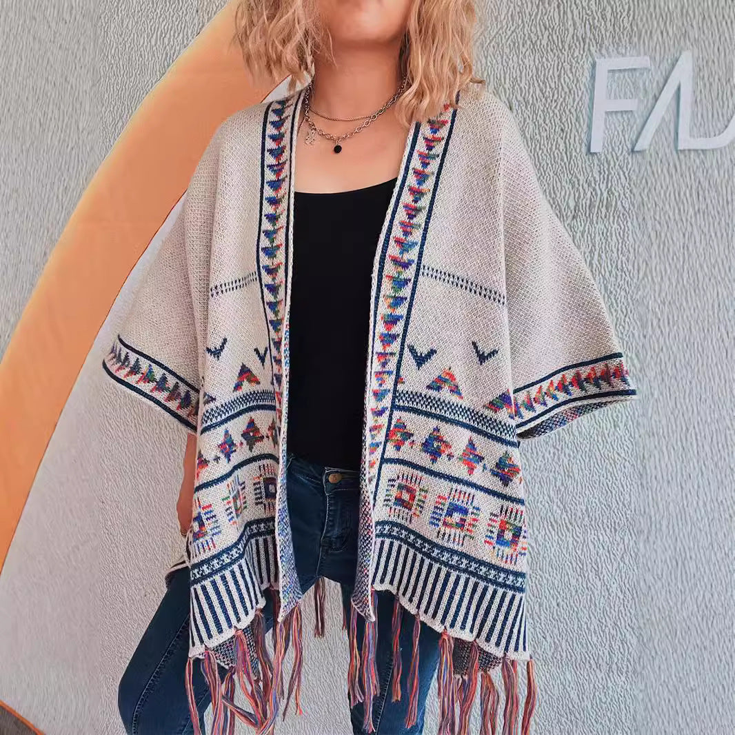 Damer fashionabel strikket poncho med frynset kant og farverigt mønster Stilla