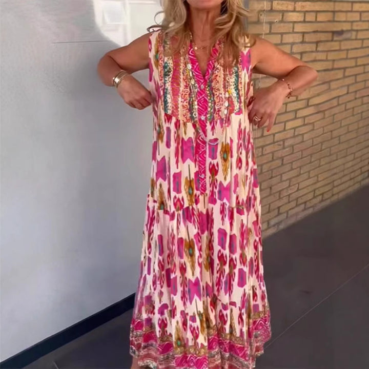 Dame i flydende maxikjole i boho-stil med V-udskæring, stribet nederdel og broderet pas Skovae