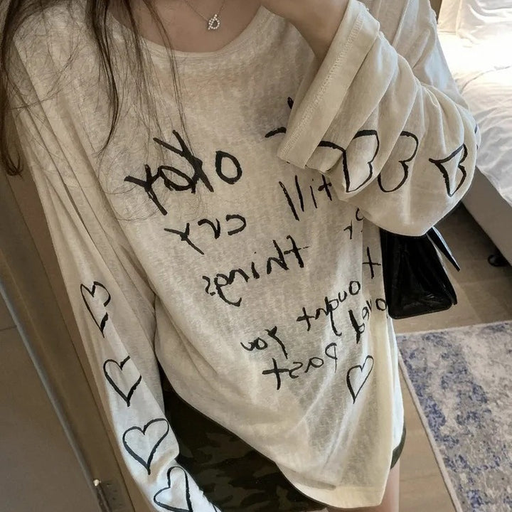 Kvinders afslappede oversized top med off-shoulder design og kunstnerisk skrifttype Stilla