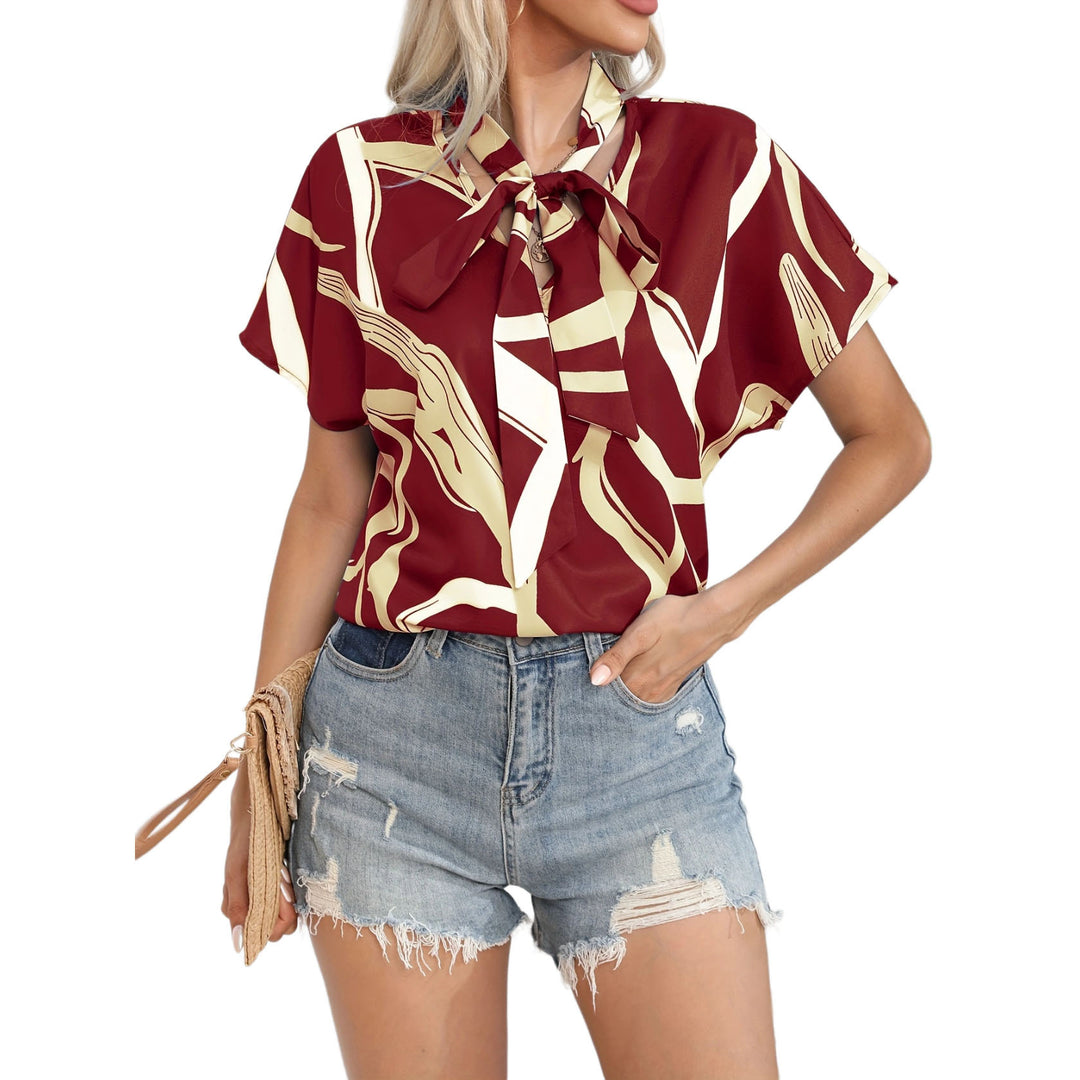 Damebluse med flot sløjfekrave og moderne grafisk design Stilla