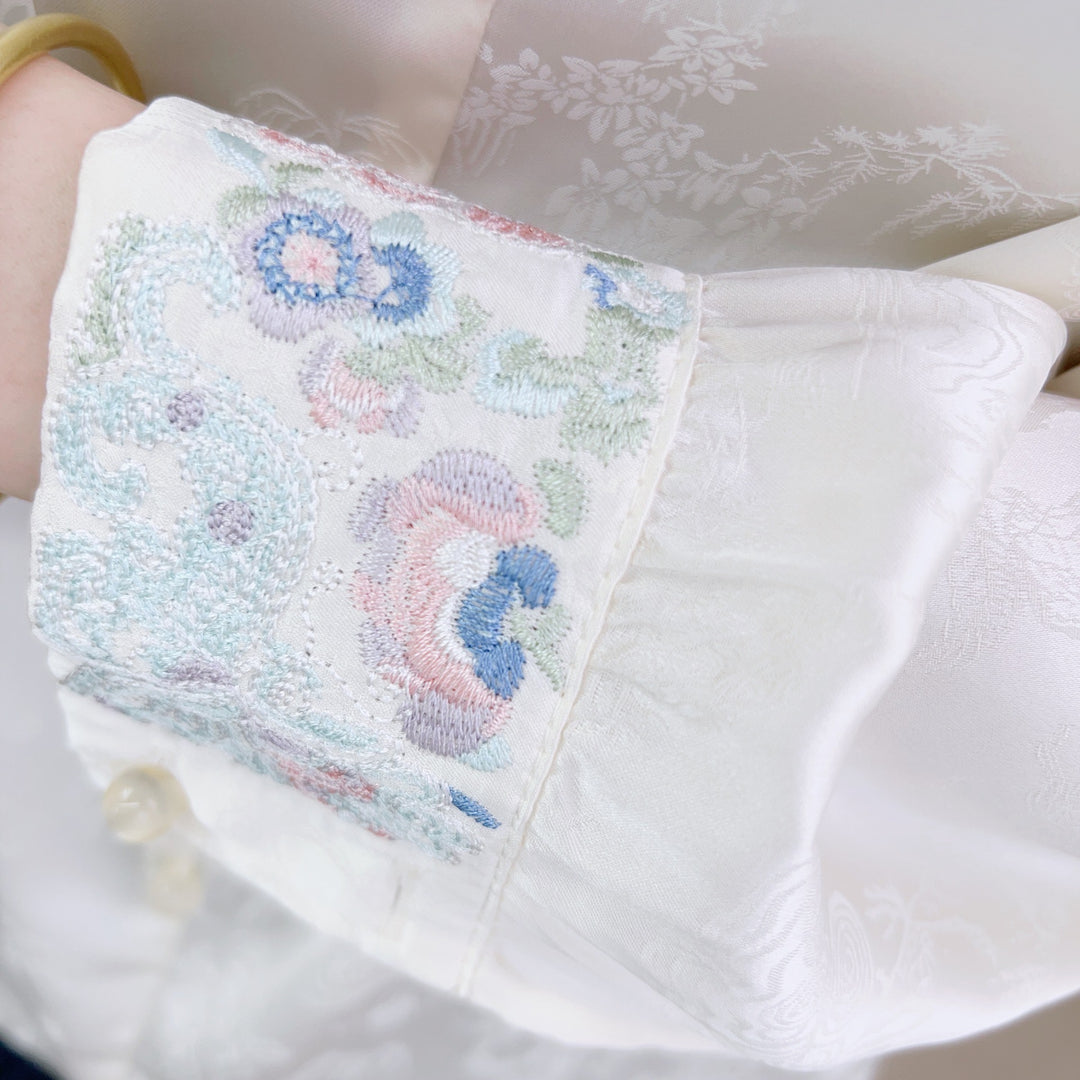 Damebluse med kunstneriske flæser og elegante perle detaljer Stilla