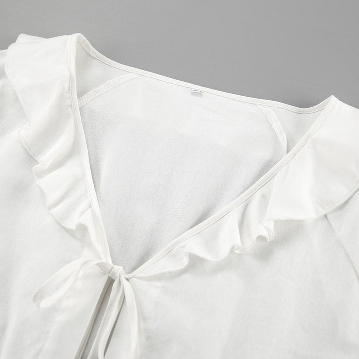 Damebluse med feminine flæsedetaljer og justerbar taljering Stilla