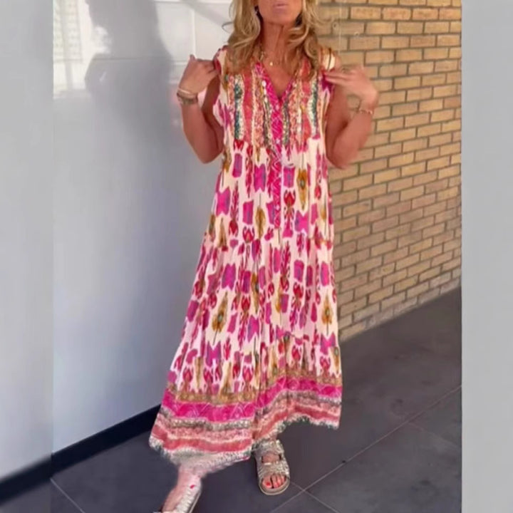 Dame i flydende maxikjole i boho-stil med V-udskæring, stribet nederdel og broderet pas Skovae