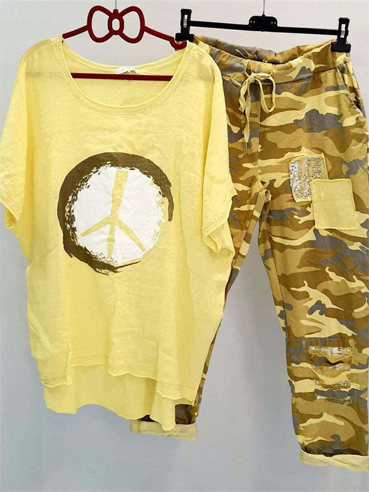 Damer med et afslappet fritidssæt med løst skåret linned-look t-shirt, fredssymbol og camouflage-joggingbukser med patchdetaljer Skovae
